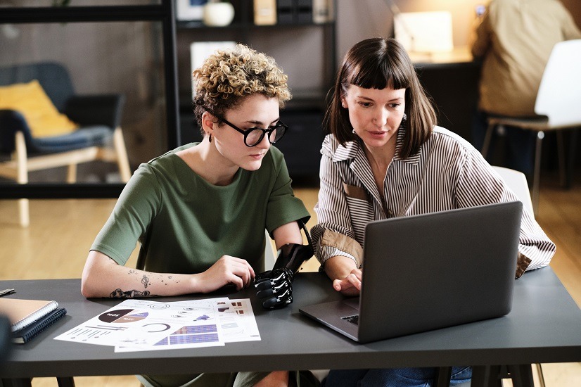 Two colleagues working on laptop in team