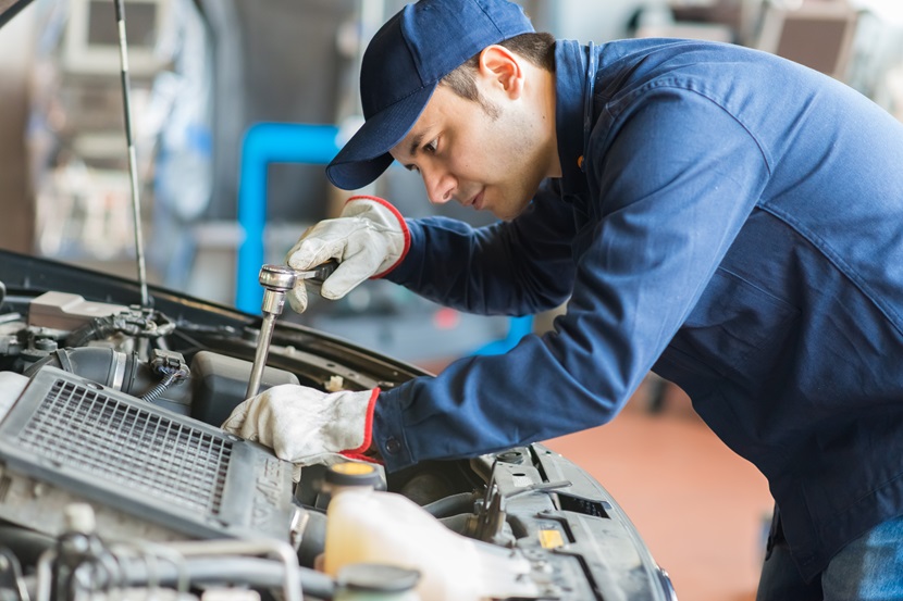 Auto mechanic working on a car in his garage