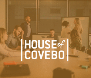 A group of employees brainstorming in the background with the company logo in front of the picture