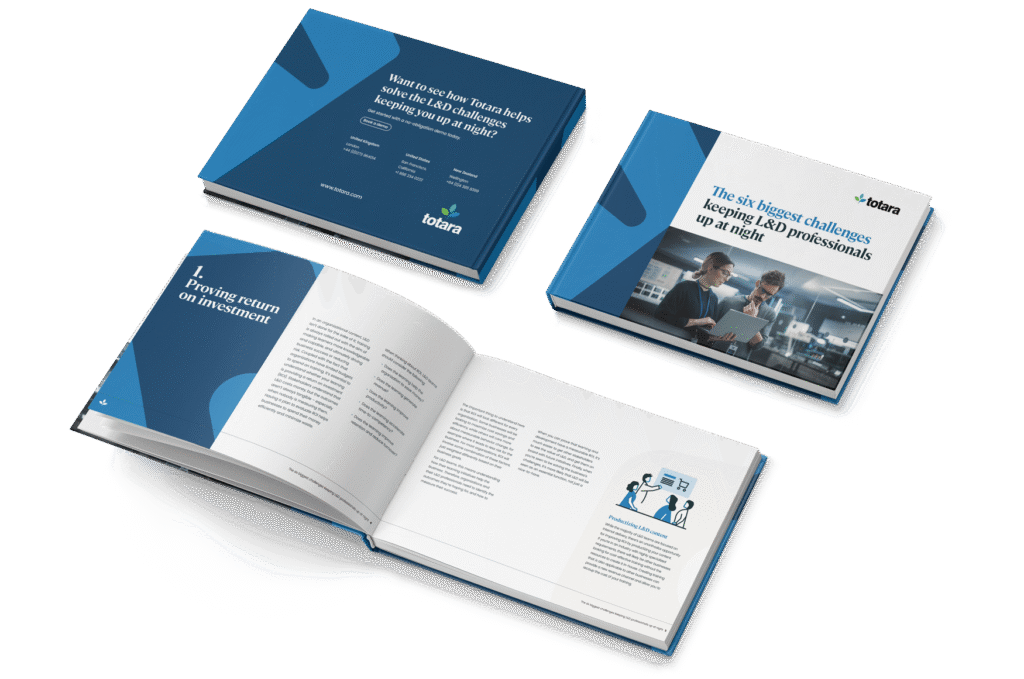 Mockup of Totara’s eBook titled The Six Biggest Challenges Keeping L&D Professionals Up at Night, featuring two professionals look at a laptop in a modern office.